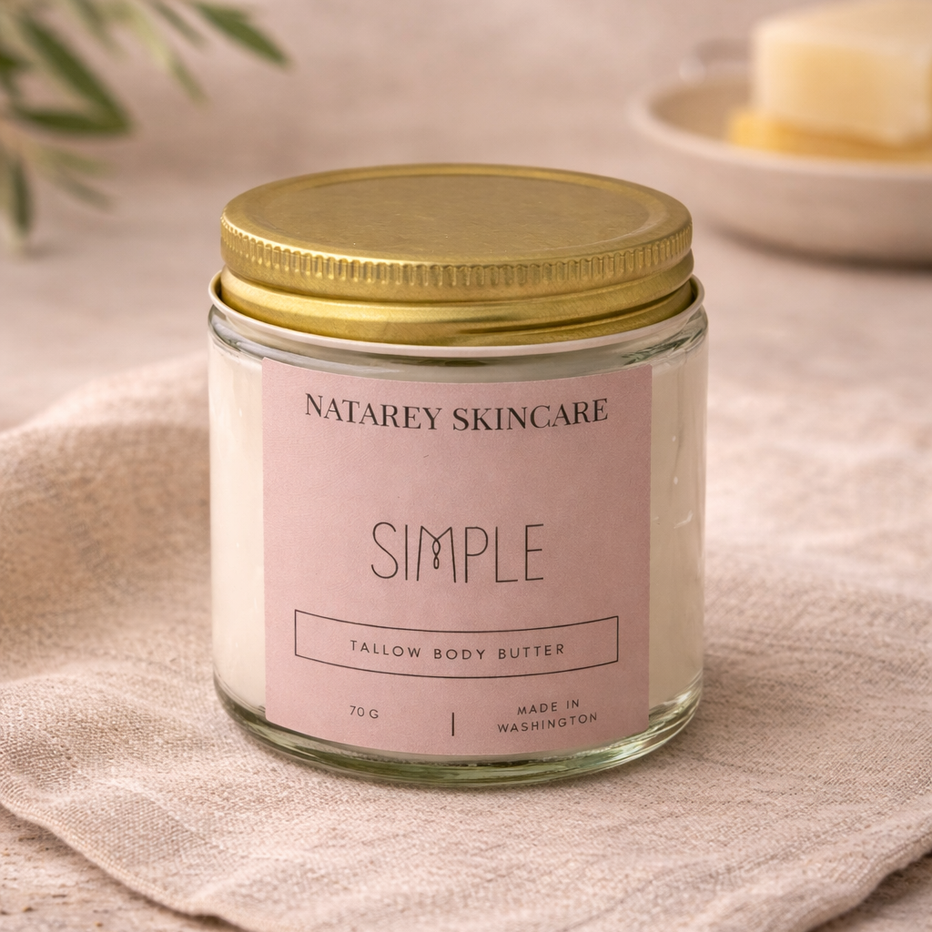 Jar of Natarey Skincare Simple Tailor Body Butter on a beige cloth with a gold lid.